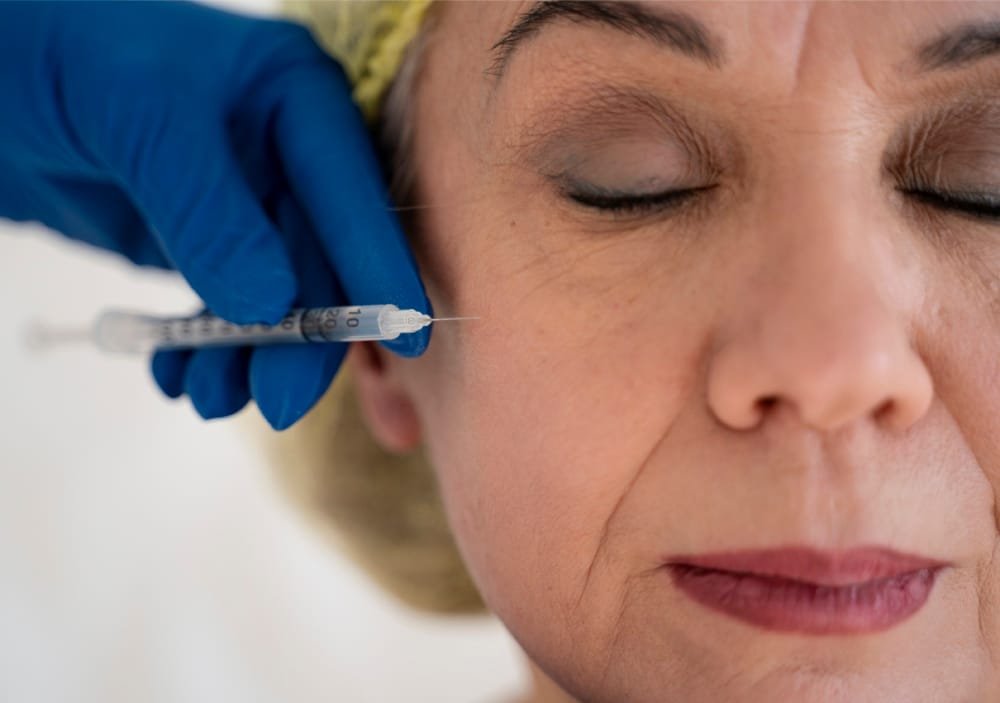 close up senior woman getting injection for anti aging treatment close up senior woman getting injection for anti aging treatment